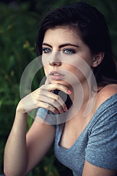 Closeup portrait of beautiful young Caucasian woman with black hair, blue eyes, looking away