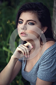 Closeup portrait of beautiful young Caucasian woman with black hair, blue eyes, looking away