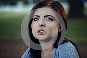 Closeup portrait of beautiful young Caucasian woman with black hair, blue eyes, looking in camera