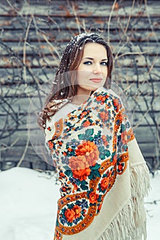 Closeup portrait of beautiful young girl with a traditional Russian or Ukrainian scarf in the winter.