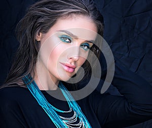 Closeup portrait of beautiful young woman in black. Professional makeup and hairstyle