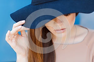 Closeup portrait of a beautiful young woman with hat outdoor looking at camera