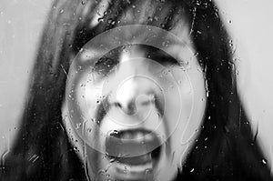 Closeup portrait of brunette girl behind glass
