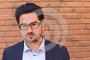 Closeup portrait of a businessman against brick wall background