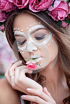 Closeup portrait of Calavera Catrina in pink dress. Sugar skull makeup. Dia de los muertos. Day of The Dead. Halloween