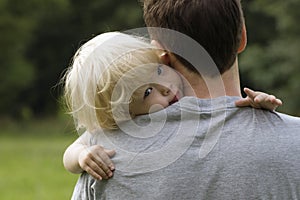 Closeup portrait of child on daddy's shoulder.