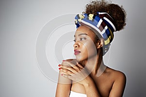 Closeup portrait of a confident young American African girl with long curly hair standing alone against a white