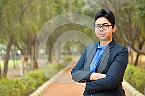 Closeup portrait of a confident young Indian Corporate professional woman with short hair and spectacles, crossed folded hands in