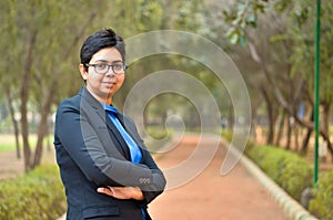 Closeup portrait of a confident young Indian Corporate professional woman with short hair and spectacles, crossed folded hands in