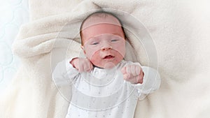 Closeup portrait of crying newborn baby lying in baby crib