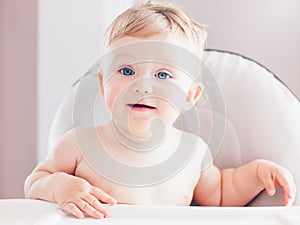 Closeup portrait of cute adorable funny blonde Caucasian smiling laughing baby boy girl with blue eyes with emotional face