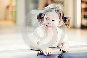 Closeup portrait of cute adorable smiling white Caucasian toddler girl child with dark brown eyes and curly pig-tails