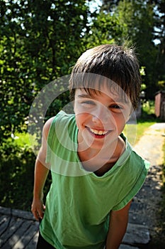 Closeup portrait cute little boy smiling in a park