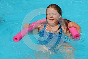 Closeup portrait of cute little girl swimming in the pool, happy child having fun in water summer vacation holidays