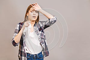 Closeup portrait of cute sick young blonde woman in casual having sore throat, holding hand on her head/Throat pain, painful