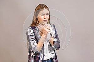 Closeup portrait of cute sick young blonde woman in casual having sore throat, holding hand on her neck/Throat pain, painful