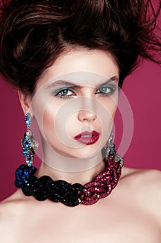 Closeup portrait with deep blue eye, creative makeup and pink purple accessories