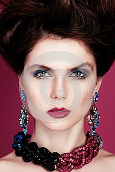 Closeup portrait with deep blue eye, creative makeup and pink purple accessories