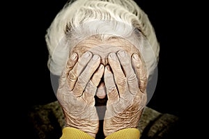 Closeup portrait depressed old woman covering her face with hand