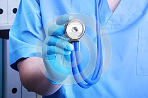 Closeup portrait of a doctor with a stethoscope on a background of a shelf with folders.