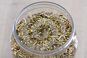 A closeup portrait of dried loose fresh viola tricolor leaves to set a fresh cup of tea in a plastic pot or jar. The herbs are