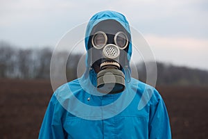 Closeup portrait of ecologist working outdoors, wearing gas mask and uniform, scientist explores surroundings, scientist works in