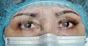 Closeup portrait of an experienced Caucasian female surgeon in a protective mask. A doctor in a medical mask is ready