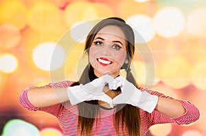 Closeup portrait of female clown mime making a heart with hands