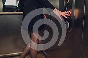 Closeup portrait of a female finger pushing elevator button.