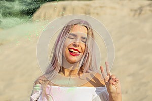 Closeup portrait of flirty blonde model playing with green dry p