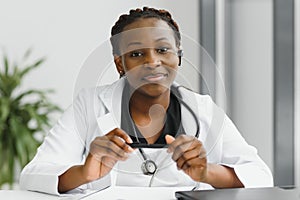 Closeup portrait of friendly, smiling confident female healthcare professional with lab coat, stethoscope, arms crossed