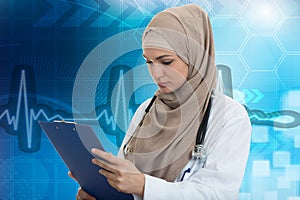 Closeup portrait of friendly, smiling confident muslim female doctor holding folder.