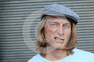 Closeup portrait, funny annoyed young childish rude bully man, on gray background. Negative emotion facial expression