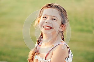 Closeup portrait of funny cute adorable smiling laughing Caucasian preschool girl with pigtails looking in camera