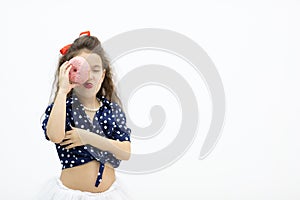 Closeup portrait funny girl with long hair having fun with colorful donut against her eye.