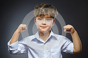 Closeup Portrait of Funny Little child. Sport Handsome Boy. Strong serious kid showing his hand biceps muscles