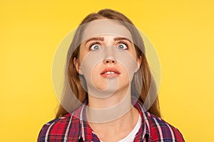 Closeup portrait of funny silly ginger woman in checkered shirt looking up cross eyed with stupid dumb face