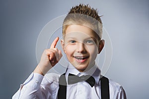 Closeup Portrait of gestured child on grey background. Boy found the idea or solution photo