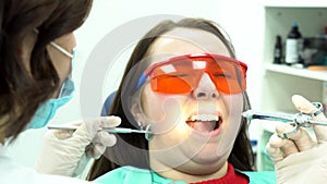 Closeup portrait of a girl scared of needles and syringes at dentist visit. Media. Female dentist making anaesthetic