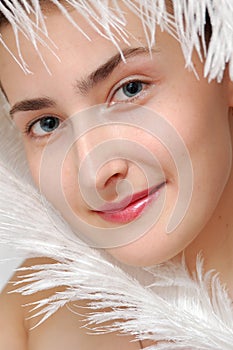 Closeup portrait girl with white ostrich feather