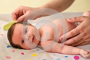 Closeup portrait: hands of father combing hair of infant baby, child is enjoying and smiling. Father care concept