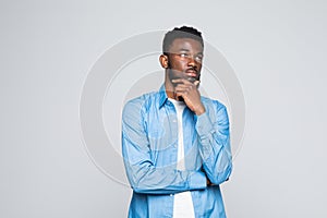Closeup portrait handsome african man looking up sideways dreaming, remembering good times hand on chin, isolated on white