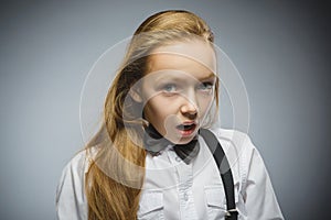 Closeup Portrait of handsome girl with astonished expression while standing against grey background