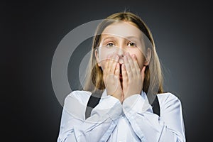 Closeup Portrait of handsome girl with astonished expression while standing against grey background