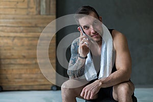 Closeup portrait of handsome man call mobile phone in gym