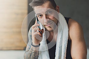 Closeup portrait of handsome man call mobile phone in gym
