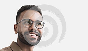 Closeup portrait of handsome smiling young man. Laughing joyful man looking up. Studio shot isolated on gray background