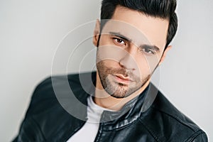 Closeup portrait of handsome thoughtful man posing on white studio background