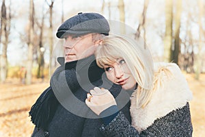 Closeup portrait of happy blonde mature woman and beautiful middle-aged brunette, looking away. Loving couple of 45-50 years old