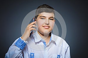Closeup Portrait of happy boy with mobile or cell phone on gray background